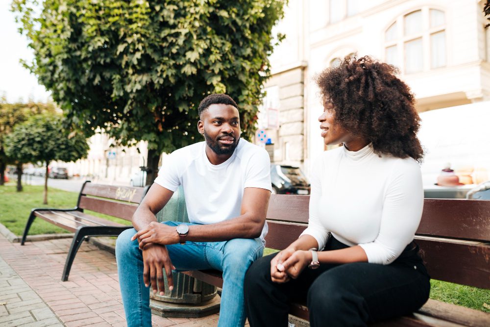 Two people talking on a park bench