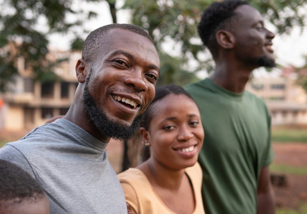 Three smiling friends and family members outdoors