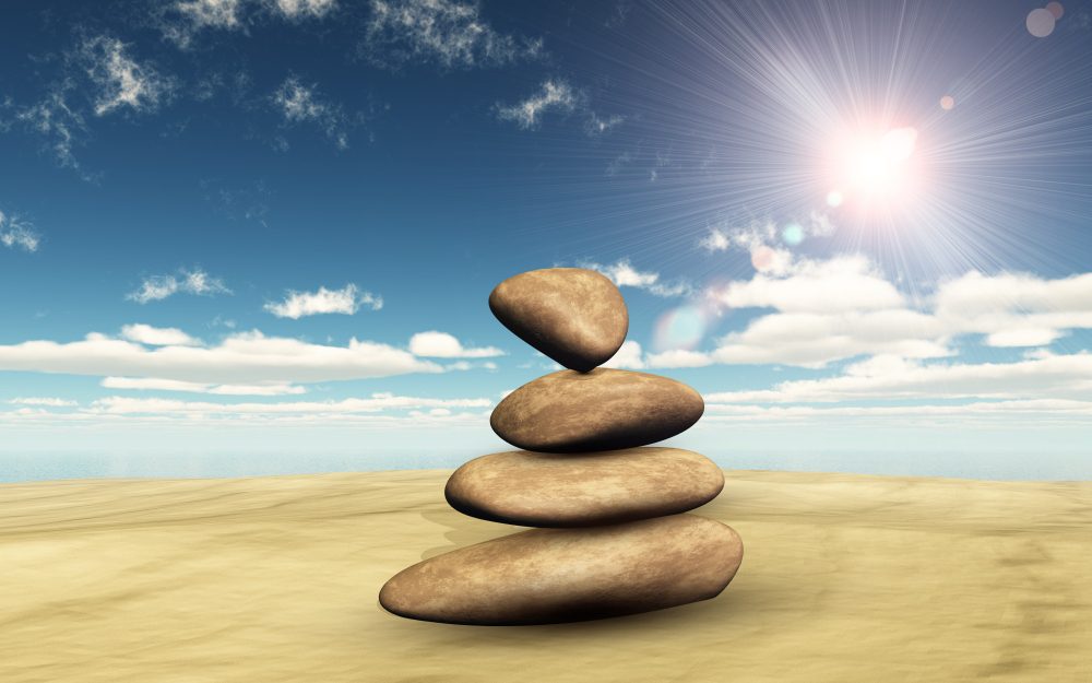 Stack of smooth stones balanced on a sunlit beach